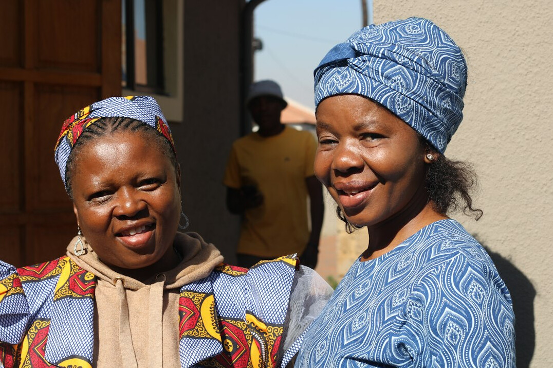 Two smiling women talking in a bright office